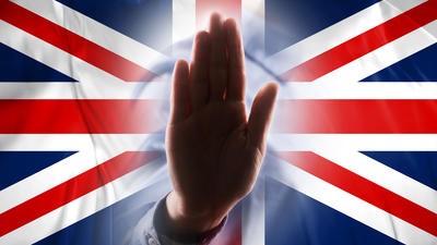 Stop sign hand in front of UK flag