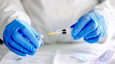 Doctor filling syringe with vaccine