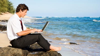 man on laptop at the beach