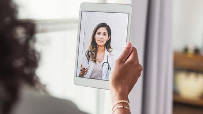 Woman speaking to a doctor virtually on a tablet