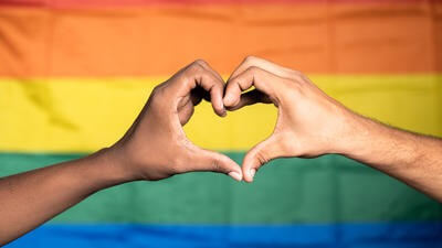 Love symbol in front of pride flag