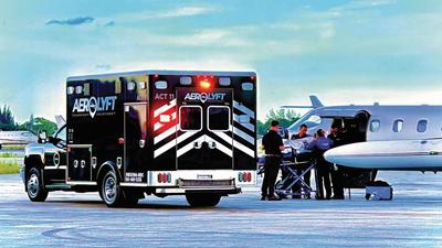 black AeroLYFT ambulance next to air ambulance aircraft