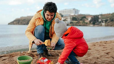 Dad and son making a sandcastle
