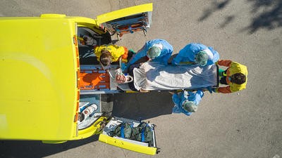 Image of person being unloaded out of an ambulance 