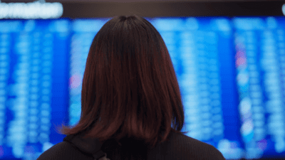 Women facing flight status board