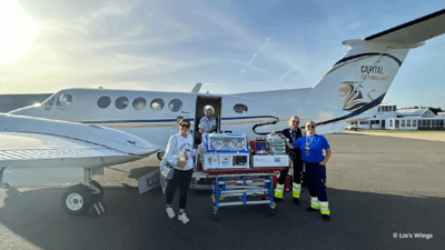 Nurses with a patient in front of a plane