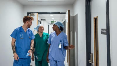 doctors having a conversation in a hospital corridor, wearing their medical scrubs