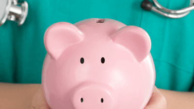 Doctor holding a piggy bank