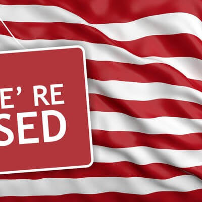 Sorry we're closed sign on US flag