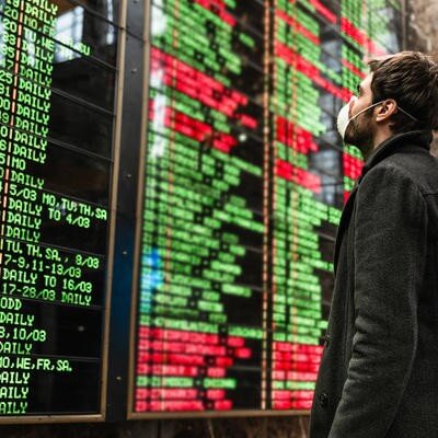 Man in mask looking at Departures board