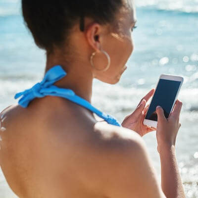 woman with smartphone at beach
