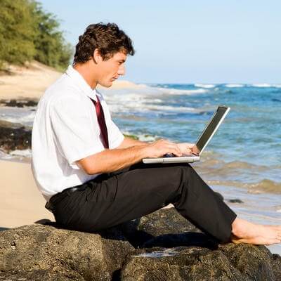 man on laptop at the beach