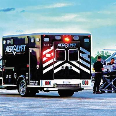 black AeroLYFT ambulance next to air ambulance aircraft
