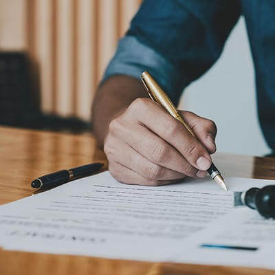 Close up of hands writing legal document 