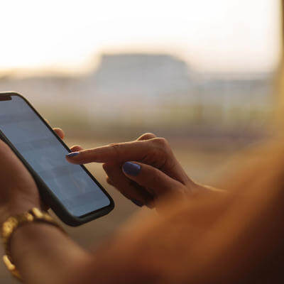 Image of person holding phone in hand with golden light