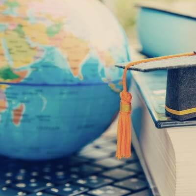 Image of graduation cap by globe