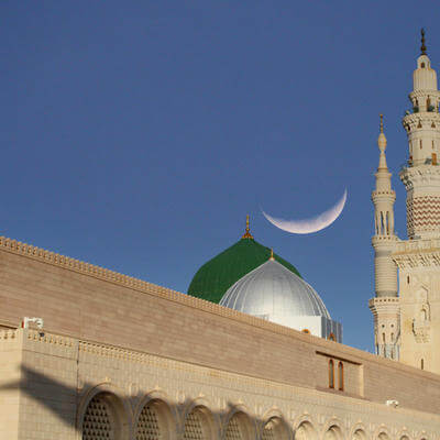 A mosque with a crescent moon in the sky