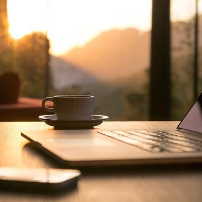 Image of mug on table next to work equipment with scenic view