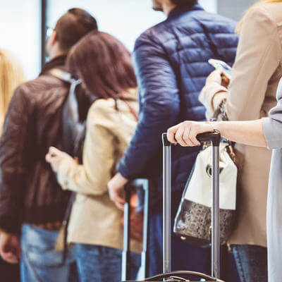 Image of passengers in queue with luggage