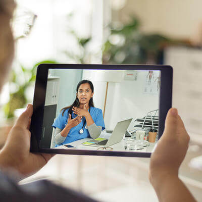 Image of GP on tablet speaking to patient