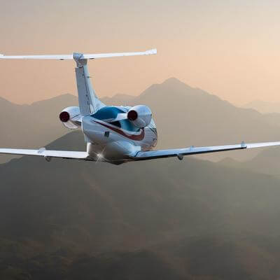 Small plane flying over mountains