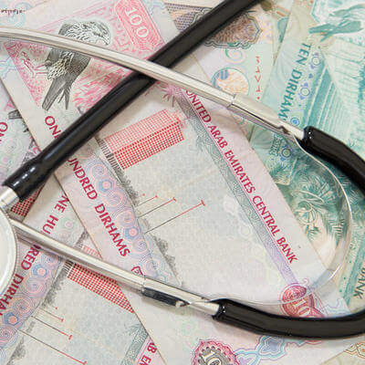 Image of medical stethoscope in front of UAE dirham