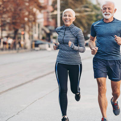 Image of two people running in city