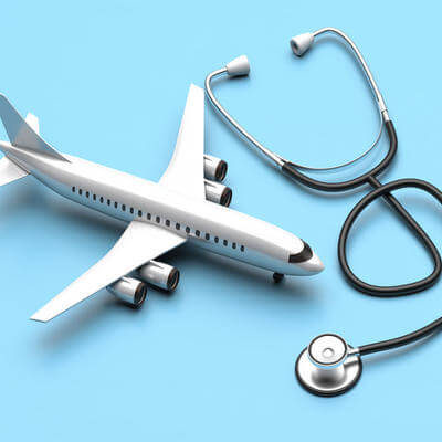 Plane model and medical stethoscope on blue background