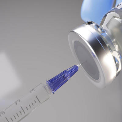 Syringe being inserted into a vaccine vial