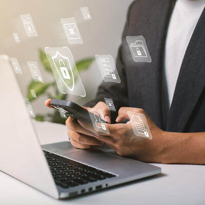 A businessman works on his laptop at home with a virtual display showing a symbol to signify cyber security privacy and online data protection