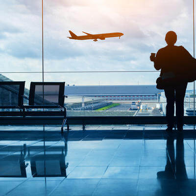 Travel by plane, woman passenger waiting in airport, silhouette of passenger in airport 