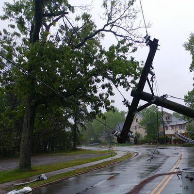 Storm damaged electric transformer on a pole and a tree
