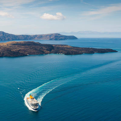 Ferry arrives at the port of Santorini Island, Greece. Blue sea and the blue sky with clouds