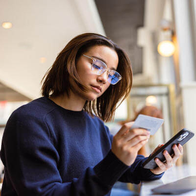 Woman making purchase on credit card in cafe