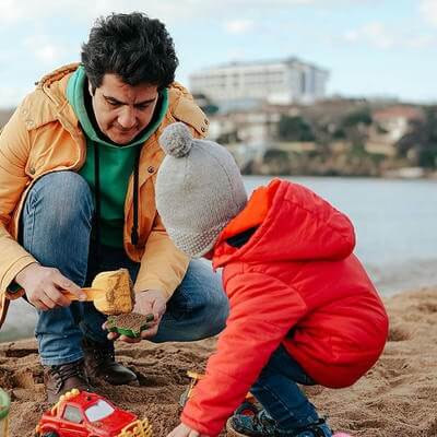 Dad and son making a sandcastle