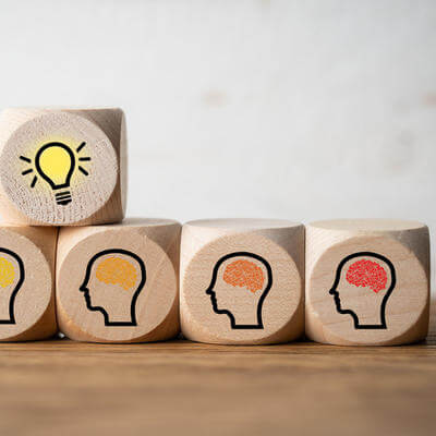 Many people together having an idea symbolized by icons on cubes