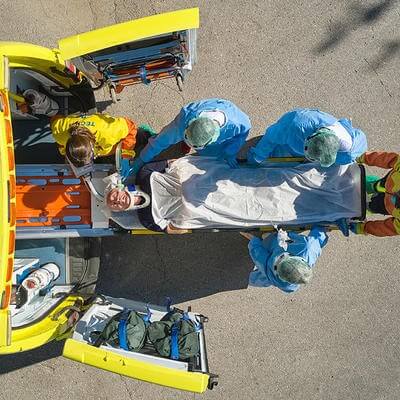 Image of person being unloaded out of an ambulance 
