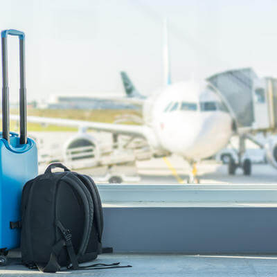 Hand luggage at the airport in front of an airplane
