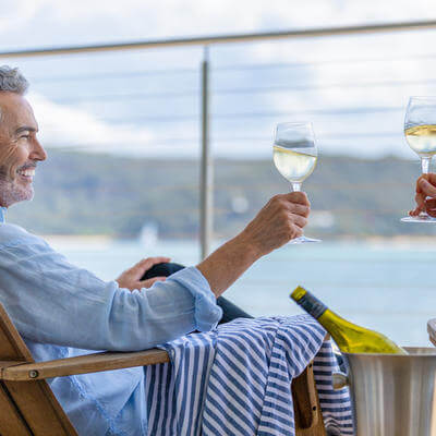 Mature couple drinking wine out on the deck