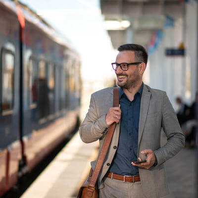 Young businessman using mobile phone at train station