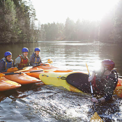 Teacher capsizing kayak in still lake