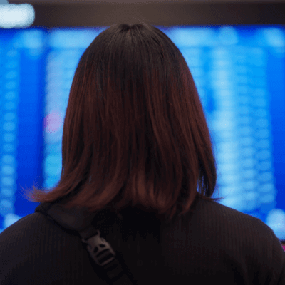 Women facing flight status board