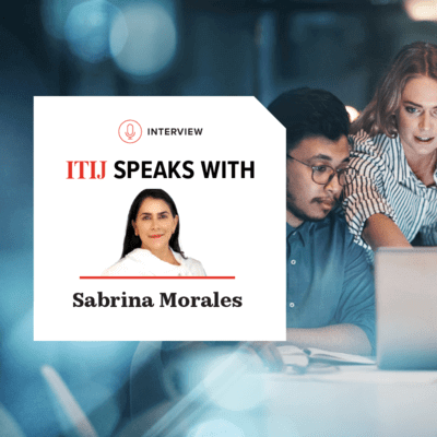 Three colleagues looking at a laptop in the office