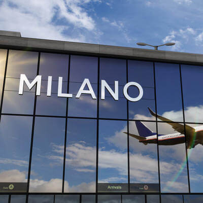 Airplane landing at Milan Italy airport mirrored in terminal 