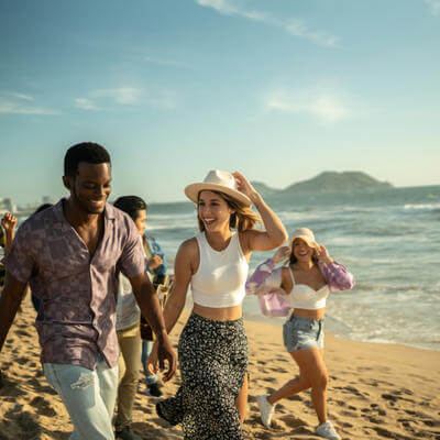 Group of young friends walking along a beach 