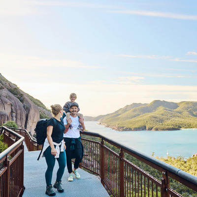 Worth the walk: Bushwalking young family in Tasmania, Australia taking in the view at Freycinet NP