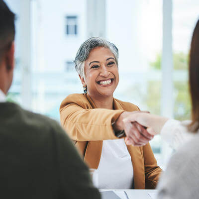 Handshake, job interview or business people with a happy mature woman for partnership in office