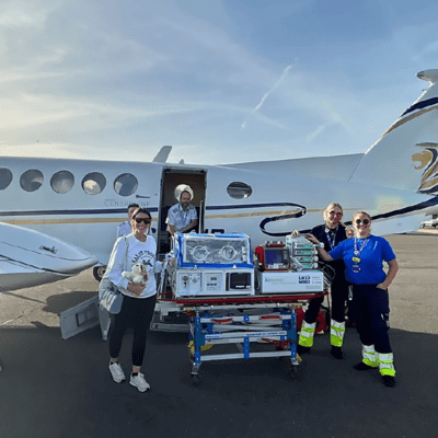 Nurses with a patient in front of a plane