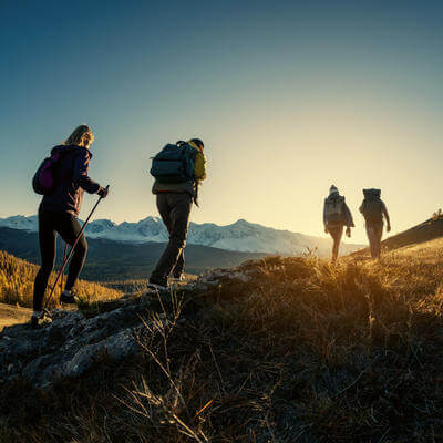 Group of hikers walks in mountains at sunset