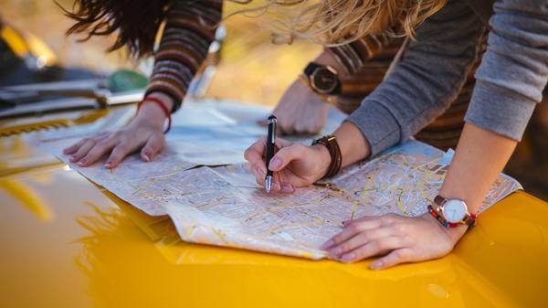 Women on trip reading map